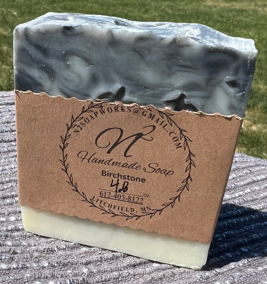 Handmade soap bar with a brown label on a textured surface